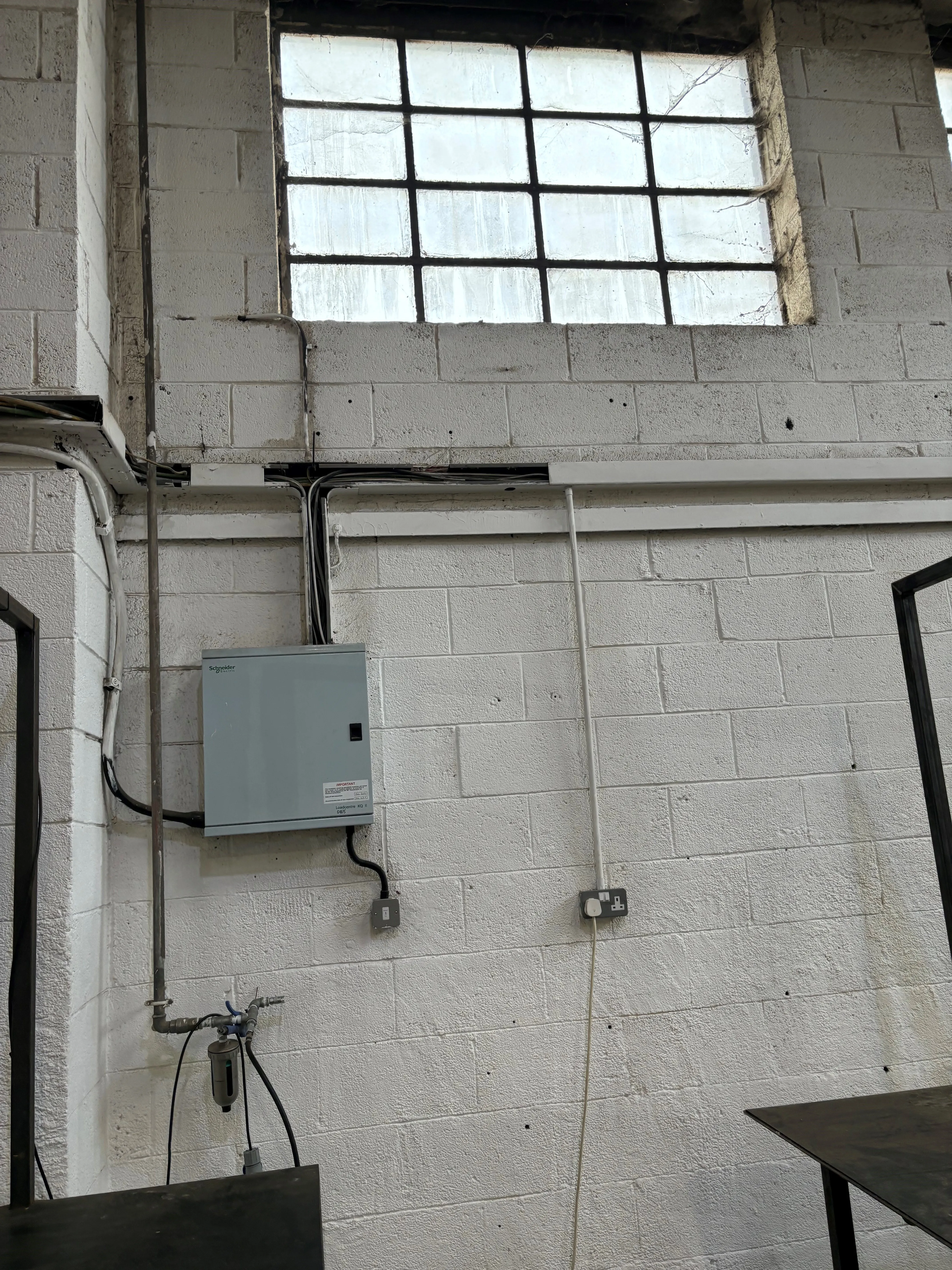 there is a box on the wall in a building with a window