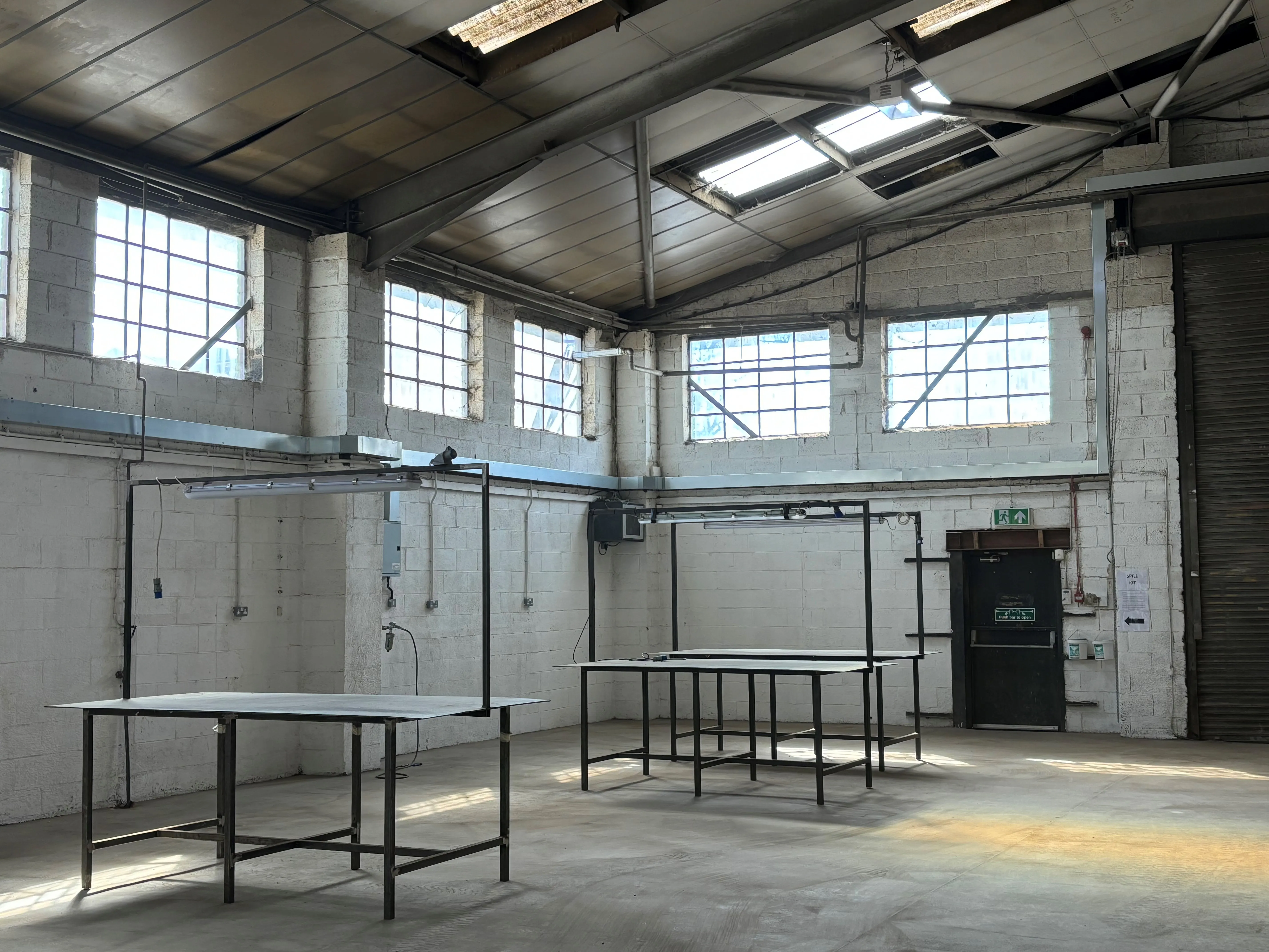 there are tables and benches in a large room with windows