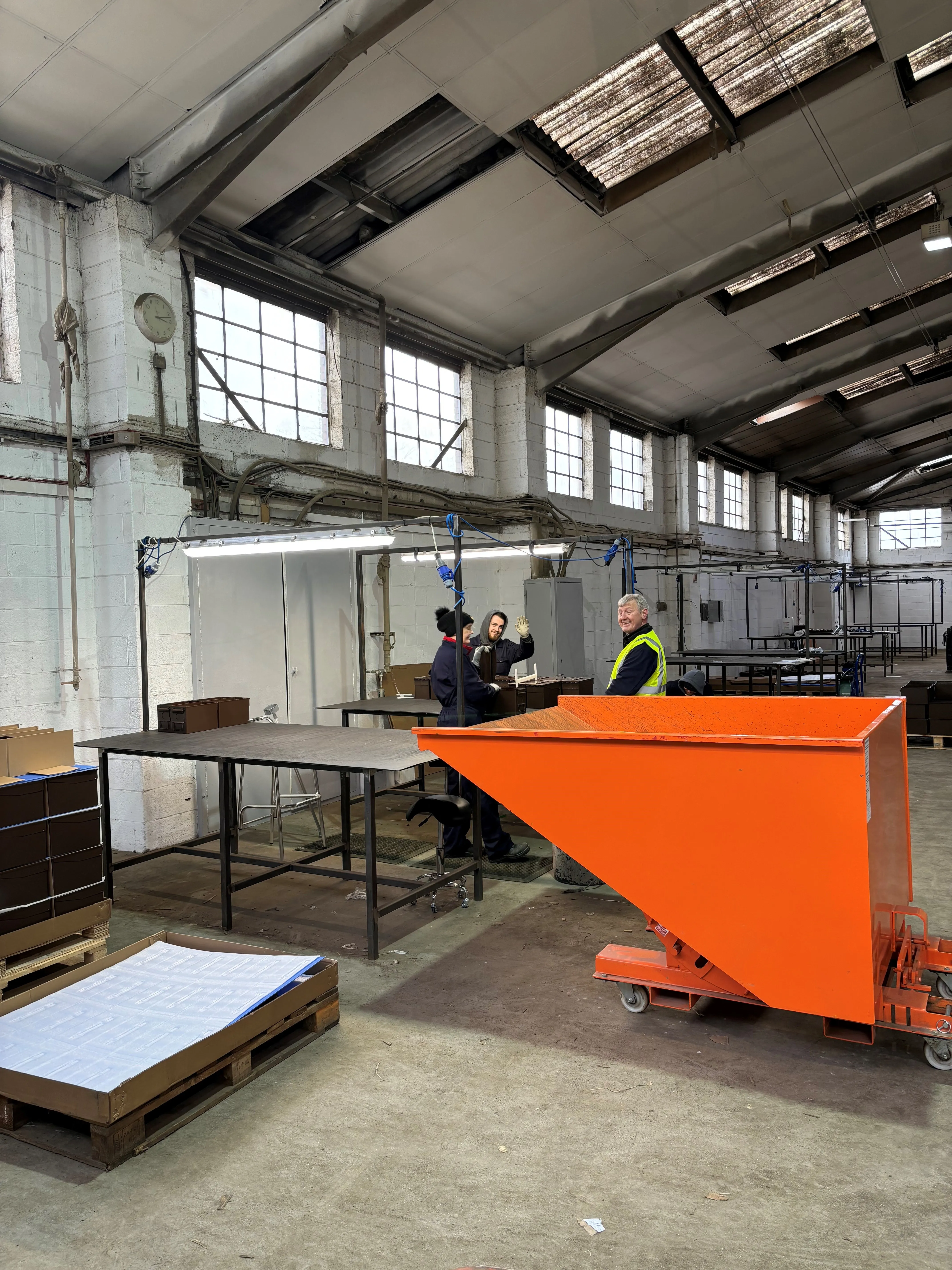 there are people working in a factory with orange bins