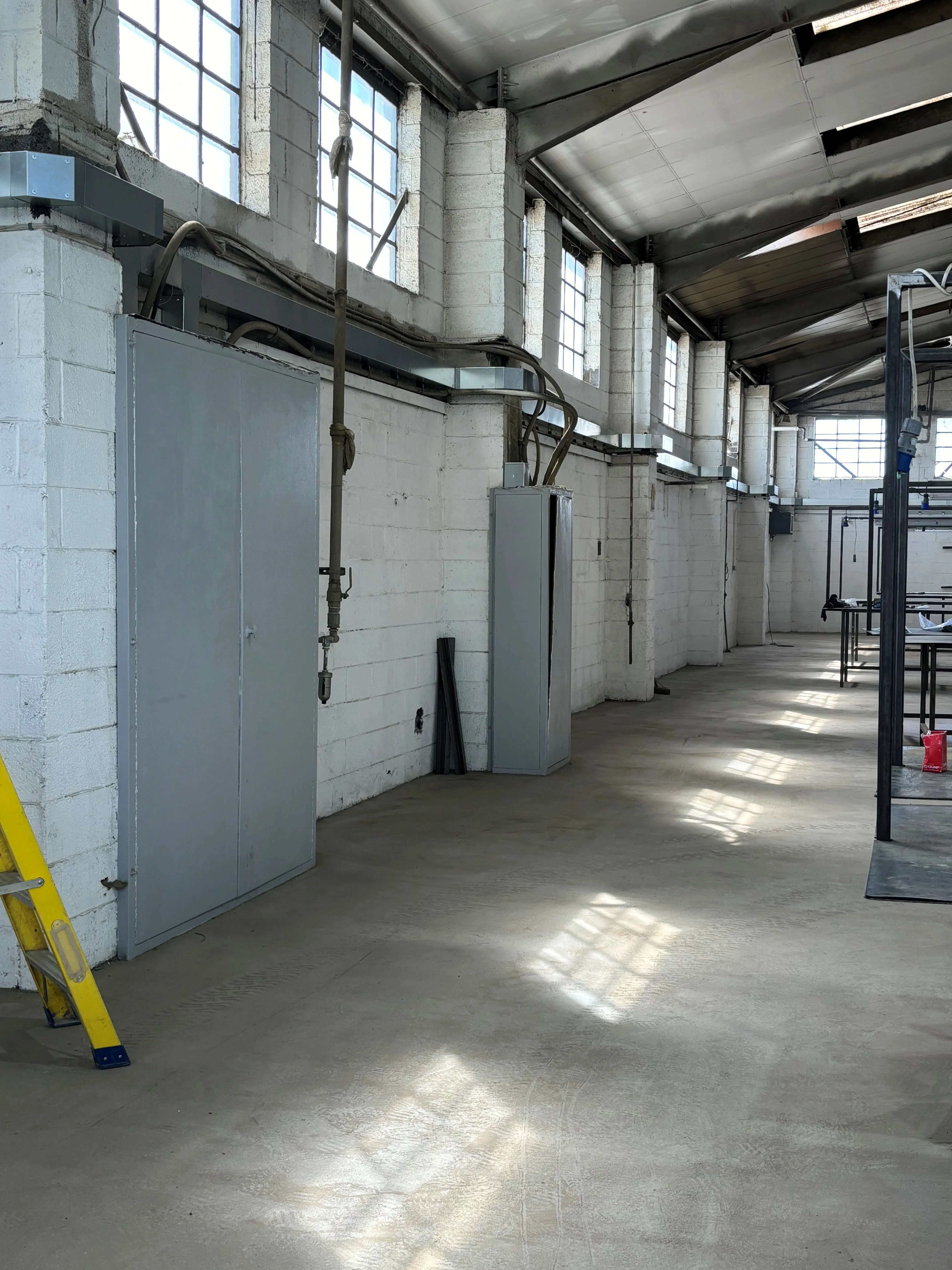 there is a yellow ladder in a large room with a white wall