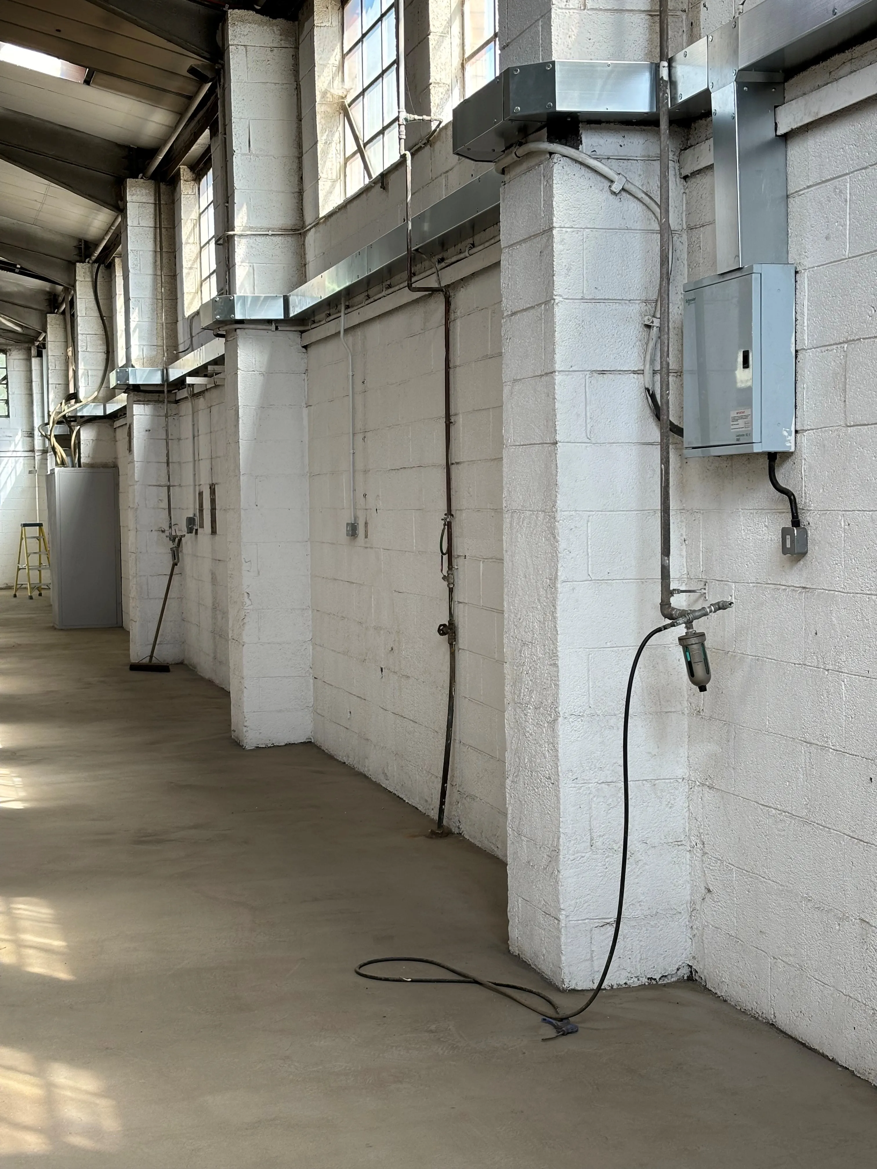 there is a room with a lot of windows and a wall with wires