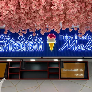 an ice cream shop with pink flowers hanging from the ceiling
