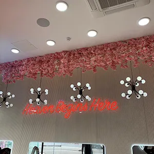 the interior of a restaurant with pink flowers hanging from the ceiling