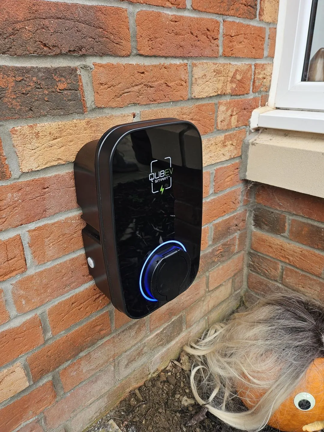 A black electronic device mounted to a brick wall.