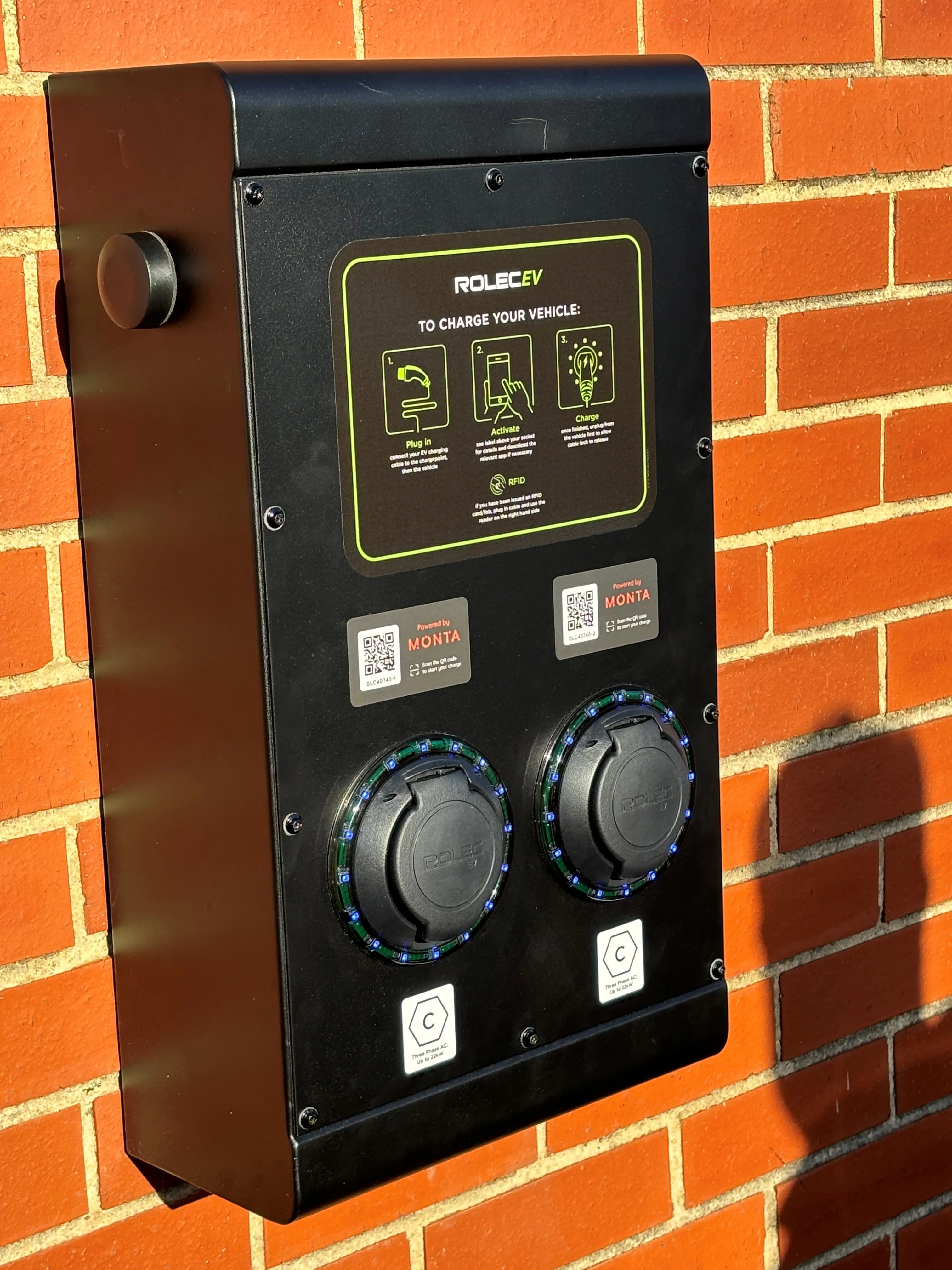 A black box mounted to a brick wall.
