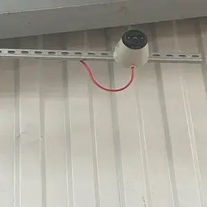 A white wall with a red cord attached to it.