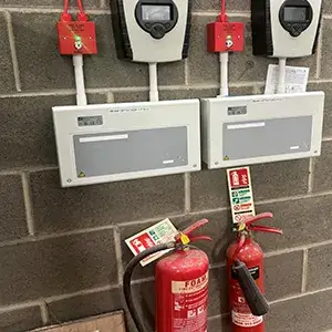 A wall with fire extinguishers on it.