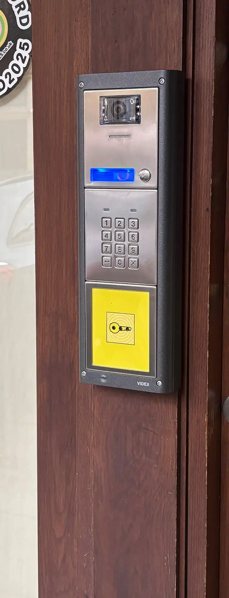A close up of a keypad on a wooden door.