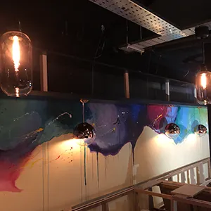 a room with a large painting on the wall and lights hanging from the ceiling