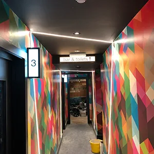 a hallway with a colorful wall and a sign on the wall